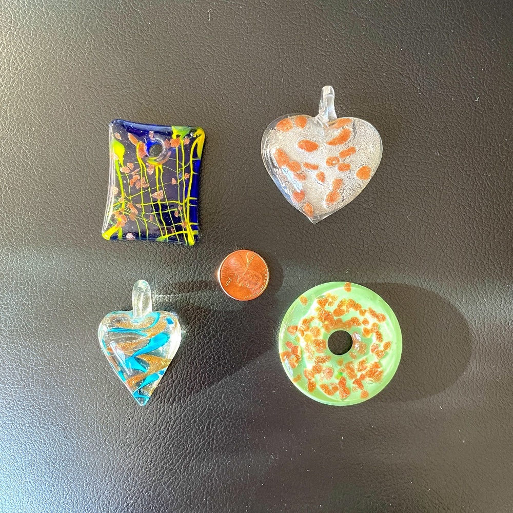 Four pendants, purple, green, white, gold, green